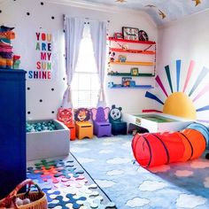 a child's playroom with lots of toys on the floor and colorful walls