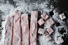 some food that is laying out on a table with powdered sugar and other ingredients