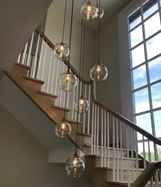 a bunch of lights that are hanging from a stair case