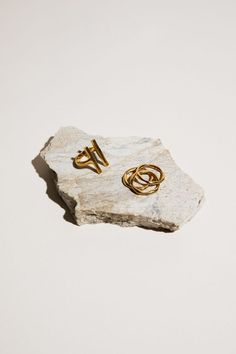 two gold rings sitting on top of a rock