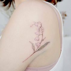 a close up of a woman's shoulder with a flower tattoo on her arm