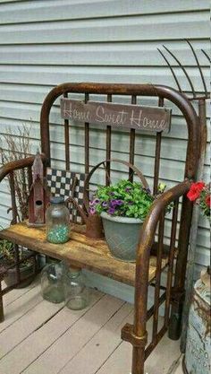 a bench sitting on top of a wooden floor next to a building with flowers in it