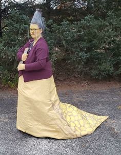 a woman in a yellow and brown dress is sitting on the ground with her arms crossed