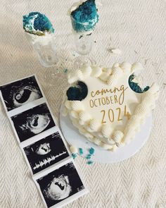 a heart shaped cake sitting on top of a table next to two pictures and an album