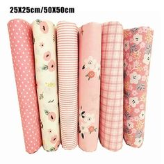 four rolls of pink and white fabric with flowers on them