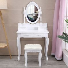 a white dressing table with a mirror and stool