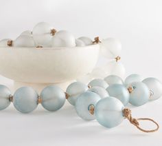 a bowl filled with white and blue glass ornaments