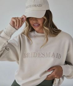 a woman wearing a bridesmaid hat and sweatshirt