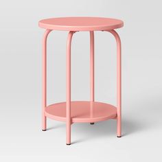 a small pink table with a round top