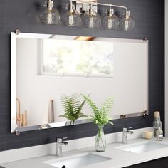 a bathroom with two sinks and a large mirror on the wall next to each other