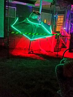 a green umbrella sitting on top of a lush green field next to a neon sign