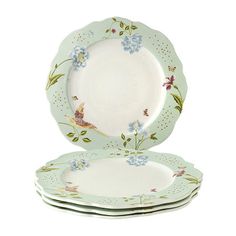 four plates with flowers and birds on them, one is green and the other is white