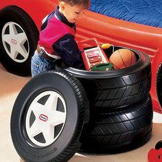 a young boy playing with toys in a toy car bed