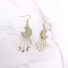 Channel the Celestial Glow with Golden Crescent Moon and Star EarringsEnchant any outfit with these magical moon earrings. Each earring features a delicate crescent moon charm adorned with stars, gracefully dangling from gleaming gold-colored hook wires.Details:Length: 2 inchesWidth: 1.5 inchesMaterial: Polymer clay, gold colored brass charms and findingsClosure: Secure pushback closureCrafted with lightweight polymer clay, these earrings measure approximately 2 inches long and 1.5 inches wide, Cottage Core Pastel, Magical Moon, Crescent Moon And Star, Moon And Star Earrings, Crescent Moon Earrings, Goth Jewelry, Gold Moon, Craft Lovers, Moon And Star