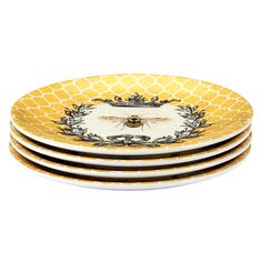 four yellow and white plates stacked on top of each other, with a bee in the middle