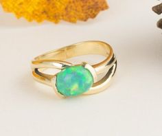 This green oval opal ring has a lovely split band. The opal is securely set with four prongs. This ring is a great gift for your opal lovers or your October babies. The rich 14k yellow gold brings out the warm tones in the stone.  Normal Price: $795.00 Metal: 14k Yellow Gold Gemstone Type: Opal Gemstone Shape: Oval  Gemstone Dimensions: 9 x 7mm  1.10 carat weight Design Elements: prong setting, solitaire ring, yellow gold Condition: New ring, estate opal  (excellent condition) Item Weight: 4.7g Polished Opal Ring In Oval Cabochon Shape, Opal Oval Cabochon Ring With Polished Finish, Polished Opal Oval Cabochon Ring, Elegant Green Opal Ring Oval Cabochon, Elegant Green Opal Ring With Oval Cabochon, Oval Ethiopian Opal Birthstone Ring, Ethiopian Opal Birthstone Rings, Oval Opal Fine Jewelry Ring, Fine Jewelry Oval Opal Ring With Polished Finish