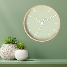 there is a clock on the wall next to a potted plant and a white vase