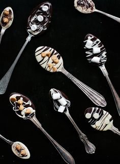 several spoons with chocolate and marshmallow toppings on them, all lined up in the same pattern