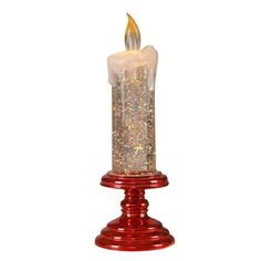 a red candle that is sitting on top of a white surface with some glitter in it