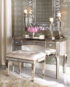 a mirrored vanity with candles and flowers on it