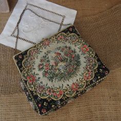 "Vintage Black Tapestry Purse / Black Handbag 1940's / Floral And Brass Clasp Evening Bag Beautiful black clutch with a floral garden design tapestry purse. The clasps is ornate gold metal with 2 black stones. Cream satin interior is in good condition with one pocket. In good vintage condition. Measures approx: 6 1/4\" x 5 1/2\" This is a vintage item , sold as is with its original charm and patina." Vintage Tapestry Bag For Evening, Vintage Evening Bag In Tapestry Material, Formal Vintage Tapestry Bag, Vintage Formal Tapestry Bag, Rectangular Embroidered Bags For Vintage Events, Vintage Tapestry Pouch Bag, Embroidered Rectangular Bag For Vintage Events, Embroidered Rectangular Bags For Vintage Events, Vintage Tapestry Bag For Formal Occasions