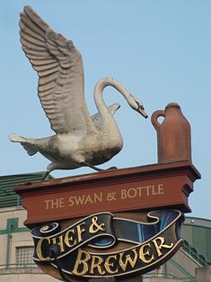 the swan and bottle sign is on top of the building