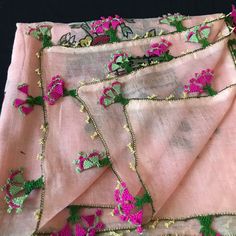 pink and green embroidered fabric with flowers on it