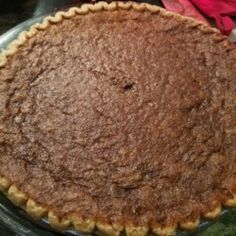 a pie sitting on top of a metal pan next to a red flowered napkin