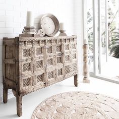 a white room with a wooden cabinet and rug