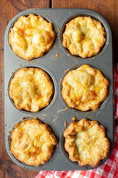 six baked pies in a muffin tin on a wooden table