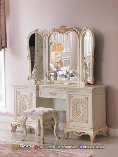 a white dressing table with a mirror and stool in front of it next to a pink wall