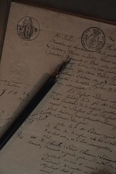 an old manuscript with writing on it and a fountain pen resting on the paper next to it