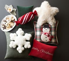 christmas pillows and decorations are arranged on a table