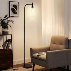 a living room with a chair, lamp and pictures on the wall