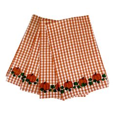 an orange and white checkered table cloth with pumpkins on it