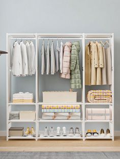 an organized closet with clothes, shoes and other items on shelves in front of a blue wall