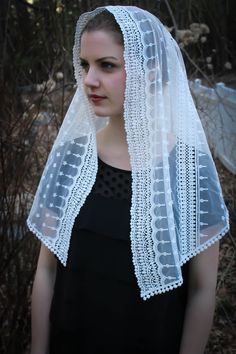 a woman wearing a white veil and black dress