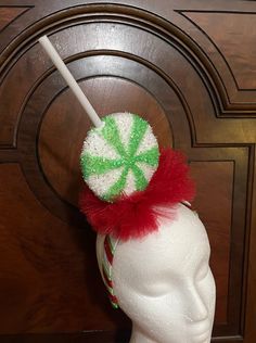 Giant size green and white swirly lollipop, sitting in red glitter tulle, attached to white satin headband, striped with red and green ribbons   Headband is one inch wide Lollipop is 8 inches in height  Super lightweight and comfortable  One size fits most Diy Big Bow, Candy Theme Birthday, Holiday Headpiece, Candy Theme Birthday Party, Big Bow Headband, Candy Theme, Ribbon Headbands, Fascinator Headband, Christmas Headband