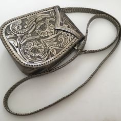 Que Chula "Itzel" Silver Hand-Embossed Leather Crossbody Purse Is New Without Tags! In Brand New Uncarried Condition. Rare! No Longer On Their Site. Brown Suede Leather Lining; Snap Closure. Make A Memorable Entrance With The "Itzel" Silver Leather Crossbody Bag By Que Chula! This Exquisite Bag Features Hand-Embossed Leather, Stitched Border Detail, And One Interior Pocket, Letting You Go From Day To Night With Uncompromising Style And Security. Plus, Its Bold, Western Design Will Have Everyone Turning Heads! Hand Embossed Genuine Full Grain Leather Removable Shoulder Strap 1 Interior Slip Pocket 8 Inches Tall At Tallest Point; 6.5 Inches Wide At Widest Point; 2.5 Inches In Depth 25 In Formal Pouch Shoulder Bag With Cell Phone Pocket, Leather Evening Bag With Coin Pocket, Formal Clutch Shoulder Bag With Cell Phone Pocket, Silver Leather Crossbody Evening Bag, Luxury Crossbody Shoulder Bag With Coin Pocket, Formal Clutch Bag With Cell Phone Pocket, Silver Leather Evening Bag For Everyday Use, Silver Leather Evening Bag, Chic Bags With Coin Pocket For Gift