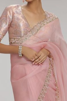 a woman wearing a pink sari and matching jewelry