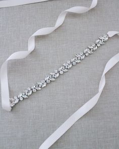 "This series of marquise and round rhinestones are attached on double-faced satin ribbon. Creates glamour and romantic finishing touch to your bridal gown, bridesmaids and flower girls. This embellished sash adds a perfect amount of sparkle to create your statement look. DETAIL: Adult Size 108\" Kids Size 78\" Applique size: 12\" length, 0.85\" wide Imported Materials Handmade in USA - We DO NOT offer refunds.  Selected items are eligible for EXCHANGE ONLY within 14 days of delivery date. All accessories are FINAL SALE.  - We are not responsible for lost or stolen items during transit. Additional insurance is available upon request. - Stay updated with latest news or promotion as we grow and follow us on the following outlets: Instagram:  http://instagram.com/shop.kaileep Facebook:  https: Silver Bridesmaid Sashes Bridal Accessories, White Crystal Sash For Formal Occasions, Formal White Crystal Sash, White Crystal Sashes For Formal Occasions, Silver Crystal-embellished Bridesmaid Sash, White Rhinestone Sashes For Bridesmaids, White Bridesmaid Sash With Rhinestones, White Bridesmaid Sashes With Rhinestones, Belt Wedding Dress