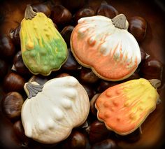 four decorated cookies sitting on top of nuts