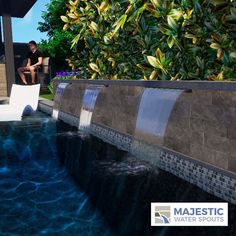 a man sitting on a chair next to a swimming pool with water running down it