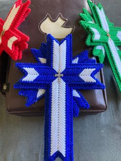 three different colored ribbons are on top of a brown purse and one has a crown