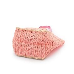 a pink knitted bag with a handle on the front and an eye patch at the bottom