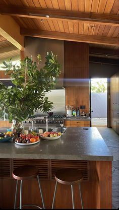 a kitchen counter with two plates of food on it and three stools in front of the counter