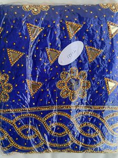 a blue and gold cloth with many different designs on the front, one has a white tag that says i love it