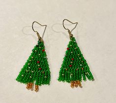 This is a beautiful glossy pair of earrings that's perfect to give your family and friends as a Christmas gift . These earrings are made with 11/0 transparent green seed beads, golden , and red seed beads  Please message me if you want earrings with different length or color . Thanks for visiting. Green Beaded Earrings For Holidays, Festive Gold Beaded Earrings, Christmas Green Dangling Beads Earrings, Christmas Green Earrings With Dangling Beads, Green Beaded Earrings For Holiday Gift, Green Round Bead Earrings For Celebration, Green Beaded Earrings For Celebration, Green Handmade Holiday Earrings, Handmade Green Earrings For Holidays