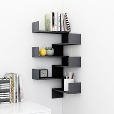 a shelf that has some books and other items on it in a room with white walls