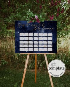 a wooden easer with a calendar on it in front of some bushes and flowers